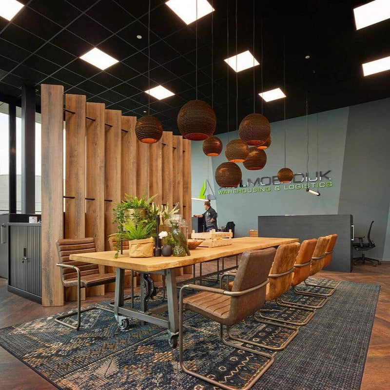 Design vergaderruimte met boomstamtafel, leren stoelen en sfeervolle kantoorverlichting