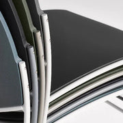 Gestapelde zaalstoelen in verschillende kleuren, geschikt voor moderne kantoorinrichting.
