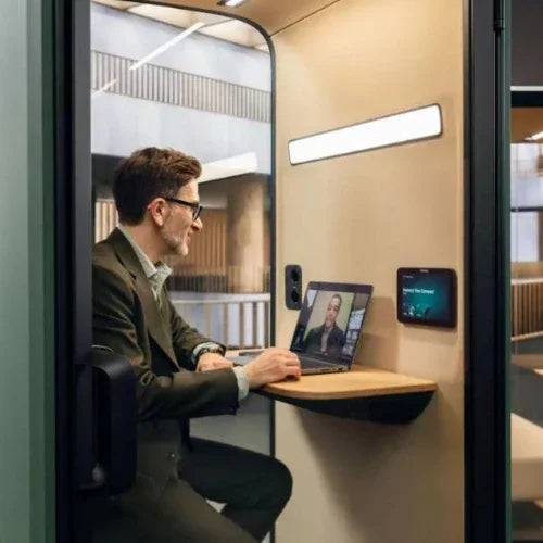 Man werkt in akoestische belcel, ideaal kantoormeubilair voor geconcentreerd videobellen.