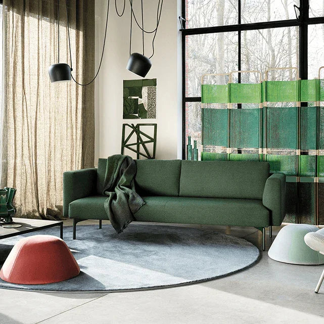 Designbank in groen met moderne kantoormeubels, lichte ruimte en grote ramen, kantoorinrichting.