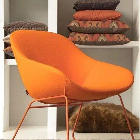 Oranje Artifort Beso lounge fauteuil voor kantoor, met metalen onderstel en kussens op achtergrond