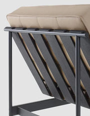 Detail van design fauteuil met beige kussen en zwart metalen frame, kantoormeubels online