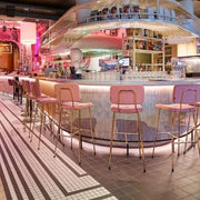 Moderne bar met roze barkrukken, design interieur en sfeervolle verlichting, kantoormeubilair inspiratie.