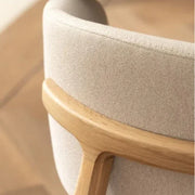 Detail van een moderne bureaustoel met houten frame en beige bekleding, kantoormeubels