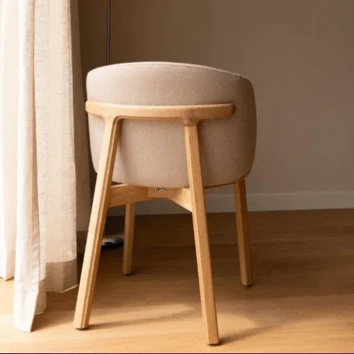Design bureaustoel met houten poten en beige bekleding in moderne kantoorruimte