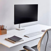 Minimalistisch modern bureau met monitorarm, toetsenbord, muis en ergonomische bureaustoel