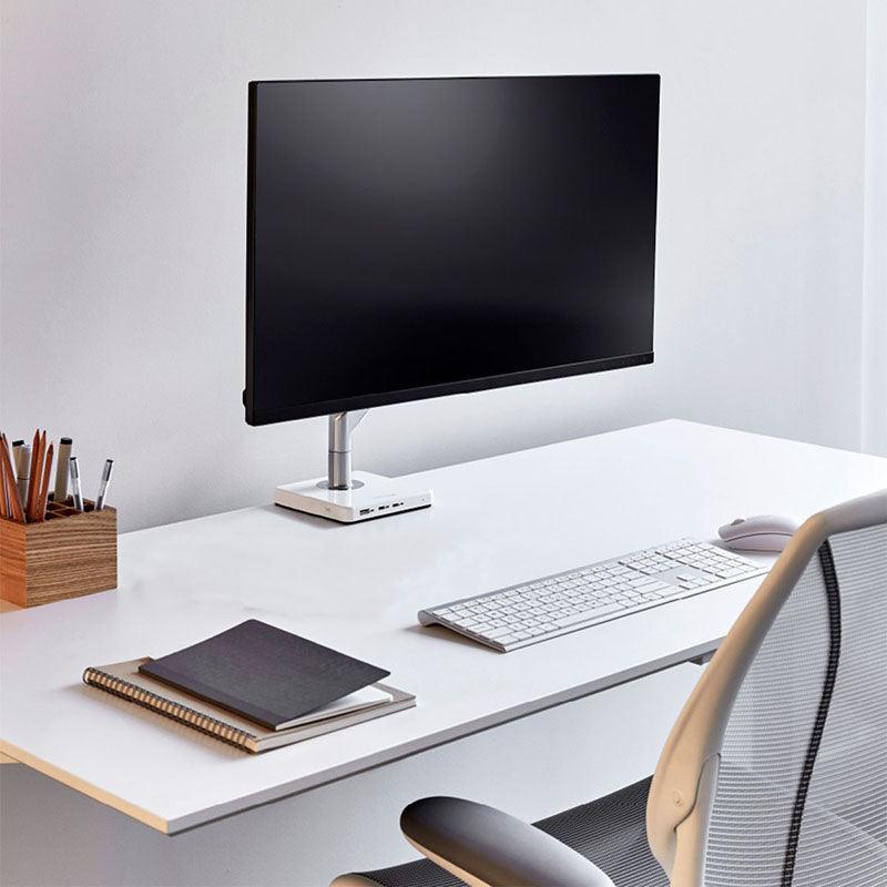Minimalistisch modern bureau met monitorarm, toetsenbord, muis en ergonomische bureaustoel