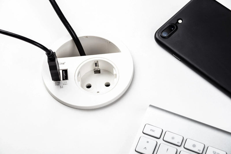 Inbouw Evoline Circle 80 stopcontact met USB lader op wit bureau bij toetsenbord en smartphone