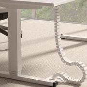 Witte kabelslurf onder modern bureau op kantoor, georganiseerd kabelbeheer meubeloplossing.