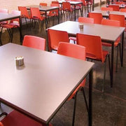 Kantinetafels met vierpoots onderstel en rode stoelen in moderne bedrijfsruimte