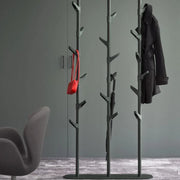 Moderne staande kapstok in een kantoorruimte met jas, rode tas en paraplu