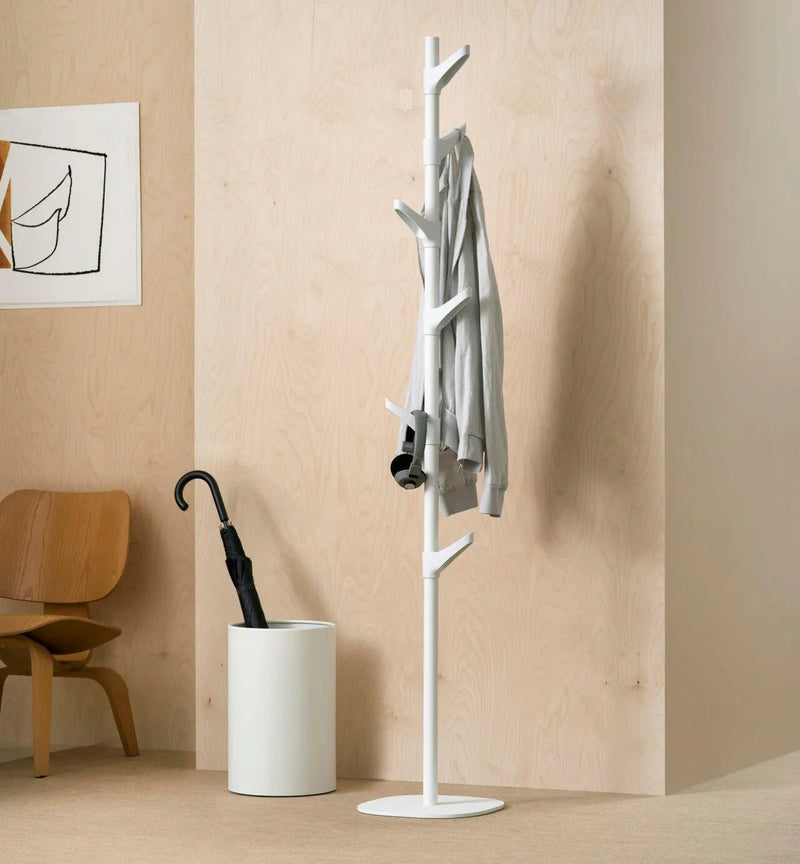 Witte design kapstok staand model in moderne kantoorruimte met jas en paraplubak