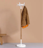 Staande houten kapstok met jas, design kantoormeubel tegen beige muur, KANTOORMEUBELS.ONLINE