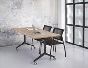 Moderne klaptafel met T-poot op wielen en twee zwarte stoelen in kantoorruimte