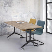 Verrijdbare klaptafel met T-poot, gele en blauwe vergaderstoelen in modern kantoor