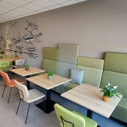 Design kantoormeubilair met kolomtafel, kleurrijke stoelen en wandillustratie kantoor