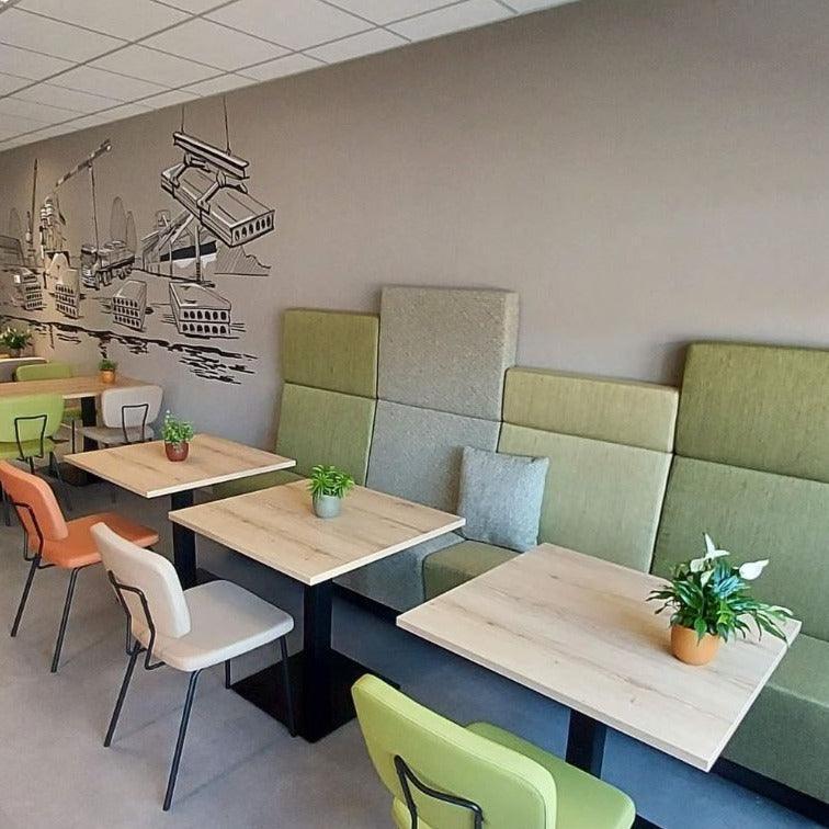 Design kantoormeubilair met kolomtafel, kleurrijke stoelen en wandillustratie kantoor