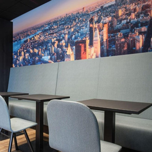 Moderne kantoormeubels met kolomtafels, stoffen banken en stoelen in werkruimte