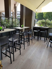 Kunststof barkrukken bij hoge tafels op modern kantoor terras, design kantoormeubilair.