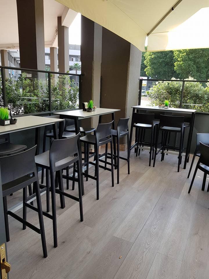 Kunststof barkrukken bij hoge tafels op modern kantoor terras, design kantoormeubilair.