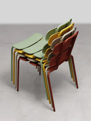 Stapelbare design terrasstoelen in groen, geel en rood, kantoormeubilair voor binnen en buiten.