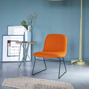 Design loungestoel in oranje stof met metalen frame, bijzettafel en kunst aan muur, kantoormeubels