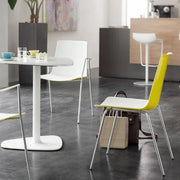 Gele design cafeteria stoel aan witte tafel in moderne kantoorruimte, kantoormeubilair sfeer