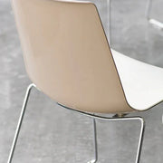 Moderne design kuipstoel met metalen sledepoten in lichte kantoorruimte, kantoormeubilair