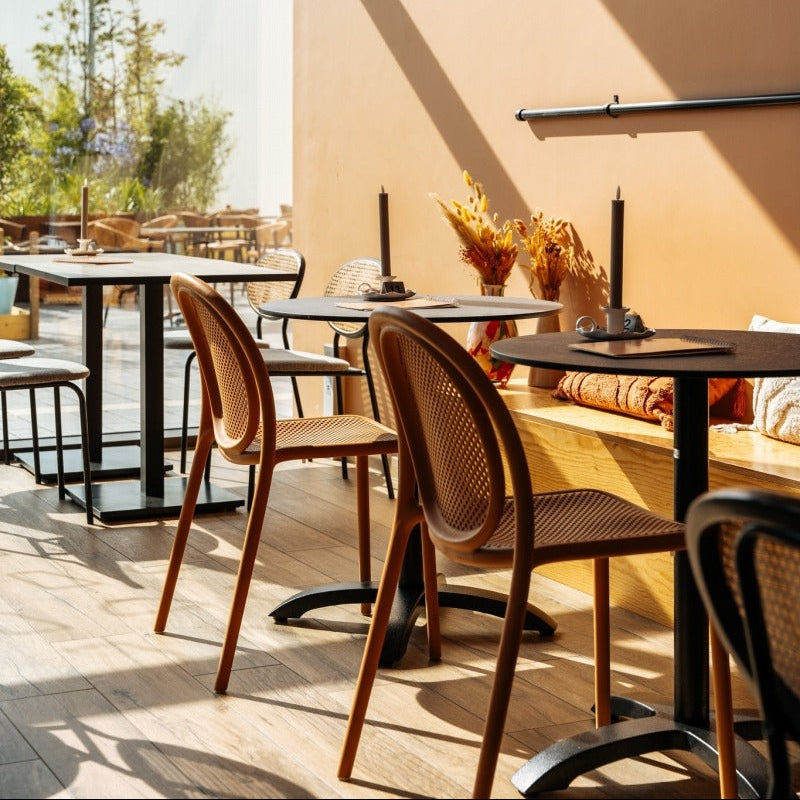 Pedrali Remind terracotta stoelen op een terras, gecombineerd met kolomtafels