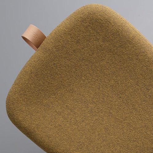 Detail van gele Artifort Lilla 2.0 poef met leren lus, modern kantoormeubilair