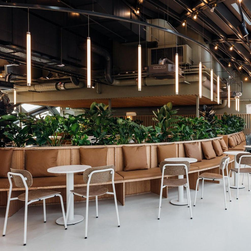 Moderne kantoorruimte met design stoelen, ronde tafels en groene planten, kantoormeubilair