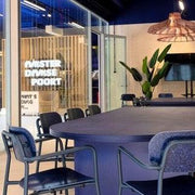Moderne vergaderruimte met design bureaustoelen, grote tafel en planten, kantoormeubels.online