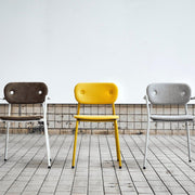 Drie design bureaustoelen in bruin, geel en grijs op tegelvloer bij KANTOORMEUBELS.ONLINE