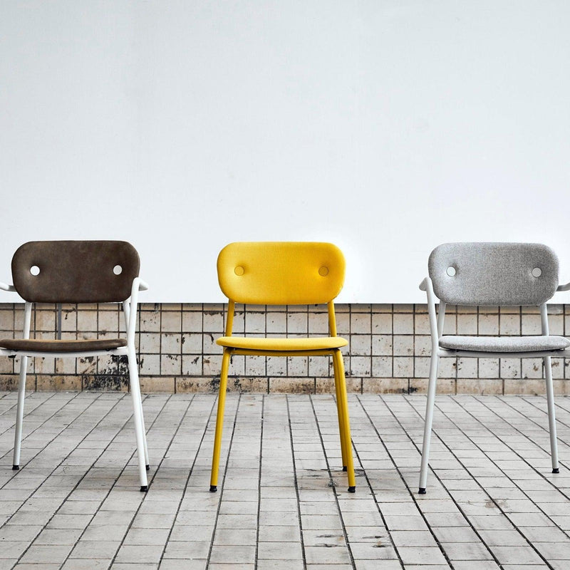 Drie design bureaustoelen in bruin, geel en grijs op tegelvloer bij KANTOORMEUBELS.ONLINE