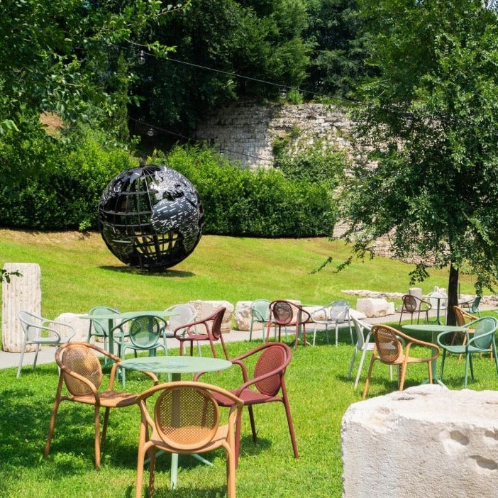 Remind Pedrali terras - stoelen met armleggers, in diverse kleuren, op een zonnig grasveld