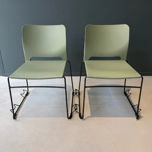 Twee kunststof zaalstoelen met koppelstukken, stapelbaar, op lichtgekleurde vloer
