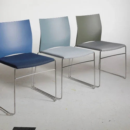 Stapelbare kunststof zaalstoelen met gestoffeerde zitting in verschillende kleuren op kantoor