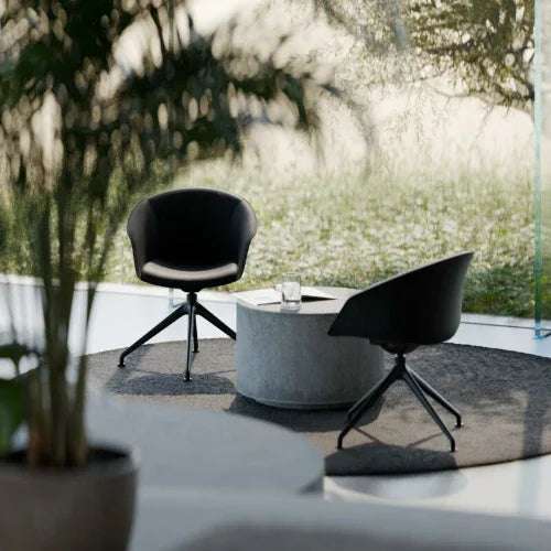 Moderne kantoormeubelset met twee zwarte designstoelen en ronde tafel in lichte kantoorruimte