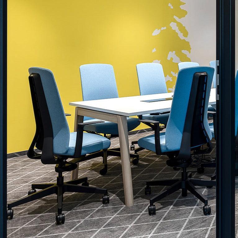 Moderne vergaderruimte met design bureaustoelen en tafel, gele wand, kantoormeubilair