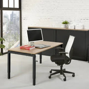 Modern bureau met zwart frame, bureaustoel en computer in lichte kantoorruimte, kantoormeubilair