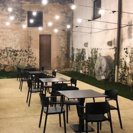 Zwarte design stoelen met en zonder armleuning buiten op terras, kantoormeubels online.