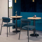 Moderne Artifort Aloa stoelen bij houten tafels en blauwe bank in kantoorruimte