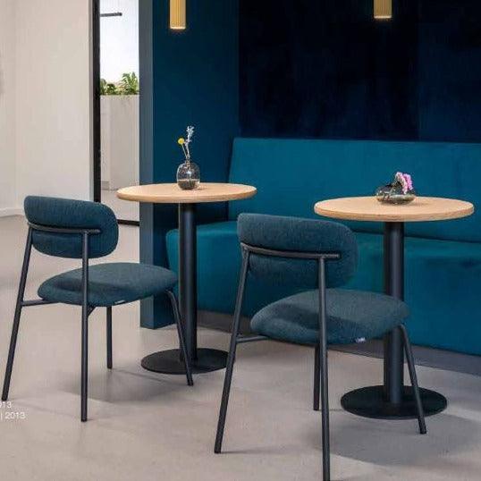 Moderne Artifort Aloa stoelen bij houten tafels en blauwe bank in kantoorruimte