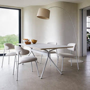 Design vergadertafel met witte Artifort Aloa stoelen en moderne booglamp in lichte kantoorruimte.