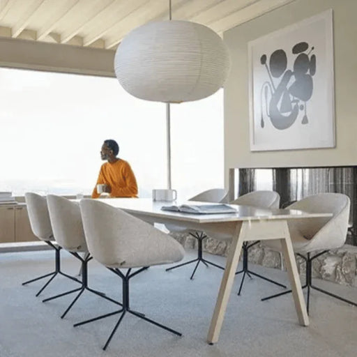 Design vergaderstoelen en tafel in modern kantoor met grote lamp en kunst aan de muur