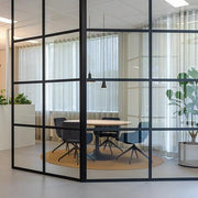 Moderne kantoorruimte met glazen wanden, ronde vergadertafel en design Artifort Jima stoelen.