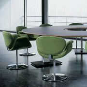 Groene Artifort Little Tulip stoel met draaibare schijfvoet aan moderne vergadertafel, kantoorinrichting