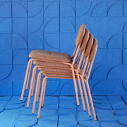 Gestapelde design kantoorstoelen met bruine bekleding voor moderne werkplekken, blauwe achtergrond