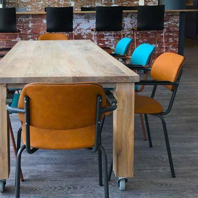 Vergadertafel met gestoffeerde kantoorstoelen met armleuningen in moderne kantoorruimte