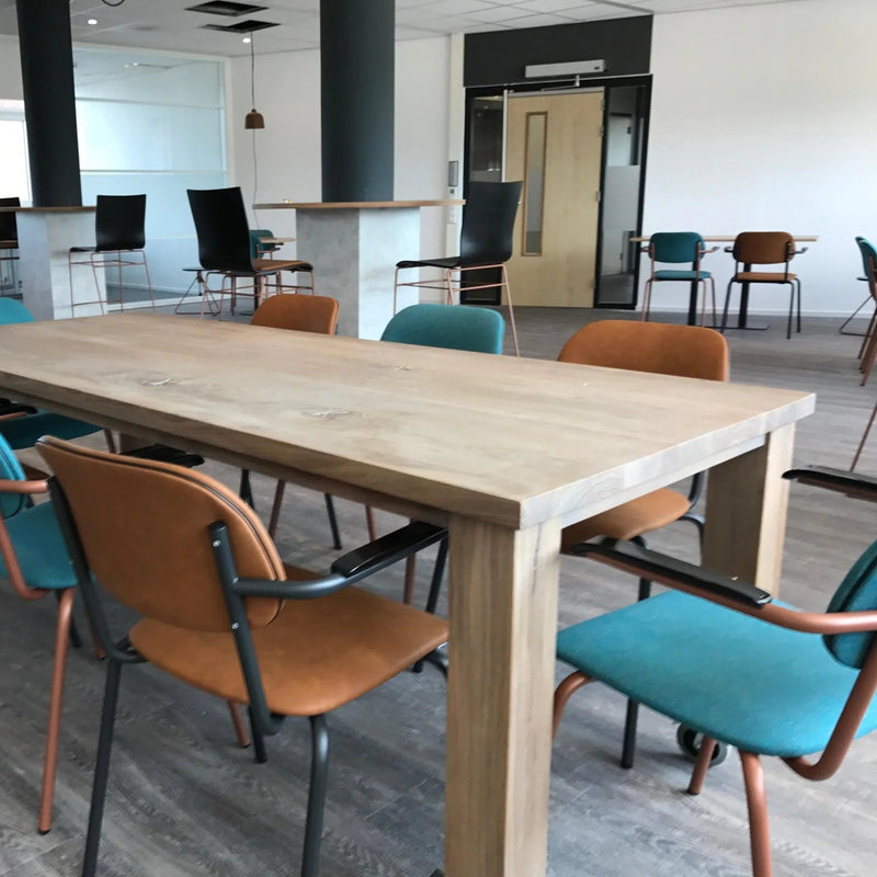 Moderne vergaderruimte met houten tafel en gestoffeerde Jami stoelen in blauw en bruin